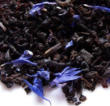 Close-up of Earl Grey black tea leaves with pieces of bergamot and vanilla, indicating a creamy texture.